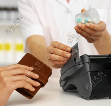 医生一手拿要一手刷卡和买药人手中的钱夹图片