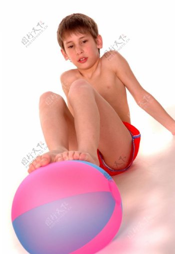 脚踩着充气球的男孩图片