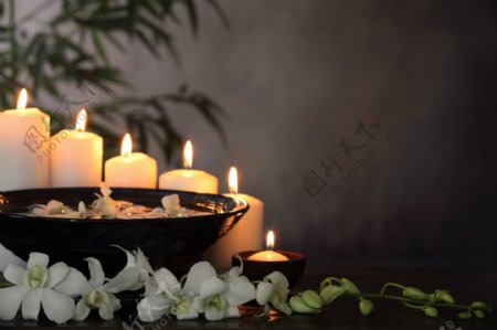 整齐的蜡烛和盘子以及花朵图片