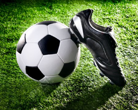 草地上的足球和球鞋图片