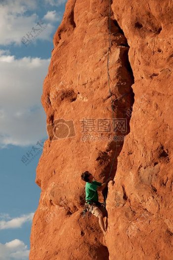 红色岩石上的攀爬的人