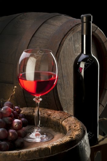 酒桶上的红酒和葡萄图片