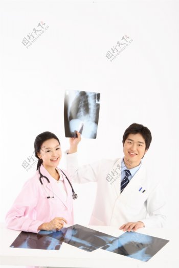 正在观看X光片的男女医生图片
