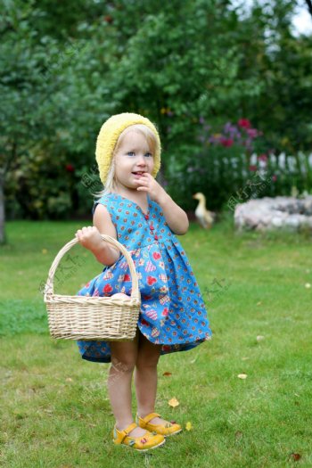 草地上提篮子的小女孩图片