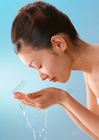 双手捧水洗脸的女人图片