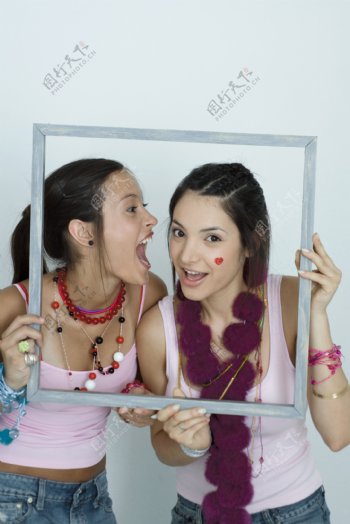 拿着框架的两个女生图片