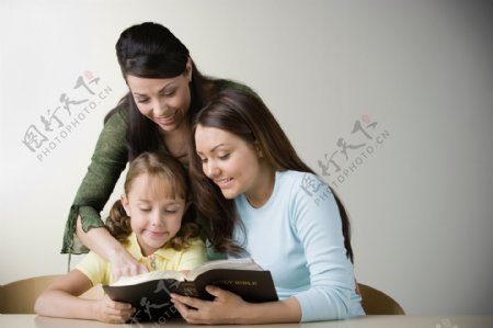辅导孩子看书的女教师图片