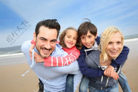 海滩上背着孩子的一家人图片