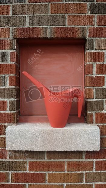 砖墙上的红色水壶