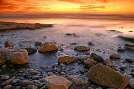 海边石滩的日落景色图片