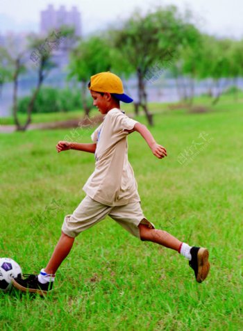 男孩草地踢足球图片
