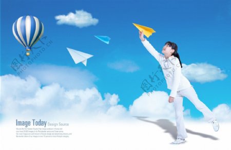 白云上放飞飞机的女孩和热气球