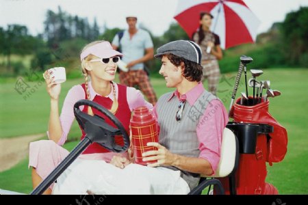 男士女士坐在高尔夫球车上图片