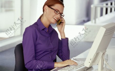 边打电话边上网的商务女性图片