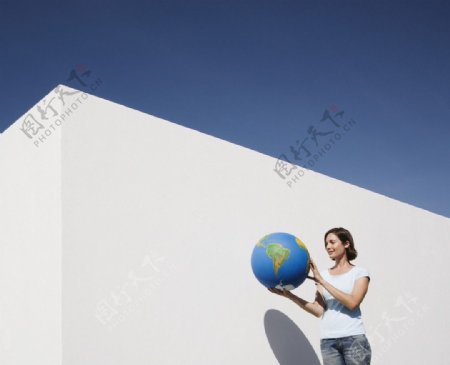 拿着地球模型的女人图片