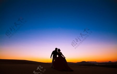 沙漠夕阳剪影婚纱照图片