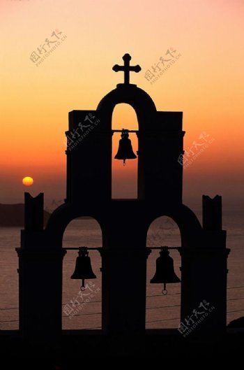 欧洲海岸的夕阳下的十字架钟声图片