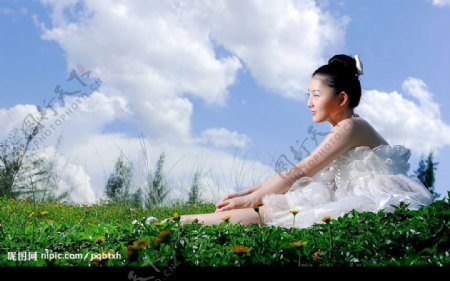 阳光下草地上的漂亮女孩图片