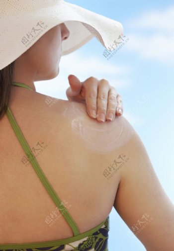 女性背部背影涂抹防晒霜着凉蓝天白云侧面夏天图片