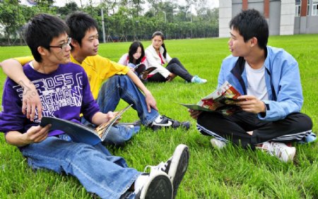 草地上看书的学生图片