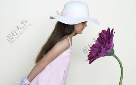 背着手看花朵的可爱小女孩图片