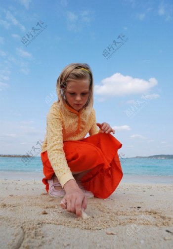 在海边沙滩上画画的小女孩图片