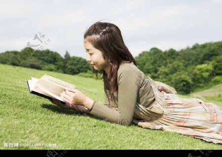 趴在草地上看书的女孩