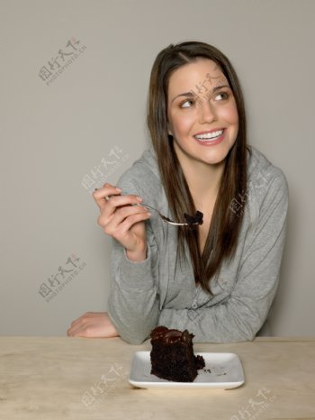 正在吃巧克力蛋糕的外国长发美女图片