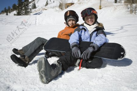 坐在雪地上的滑雪姐弟图片