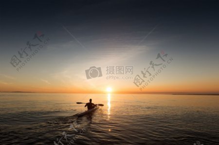 男子在日出海上逆水行舟