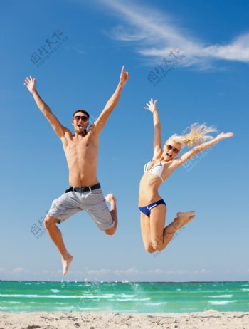 沙滩上跳跃的外国情侣图片