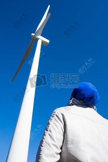 一个人在看白色风力发电栏杆
