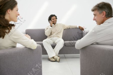 坐在灰色沙发上的三个商务人士图片