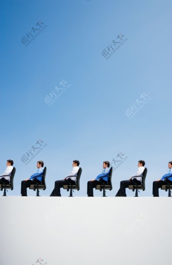坐在沙发上成一排的商务男人图片
