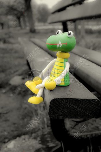 坐在长凳上的彩色青蛙