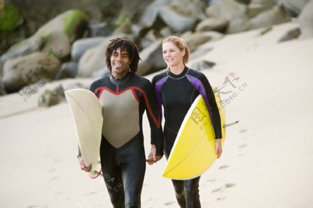沙滩上拿冲浪板的情侣图片