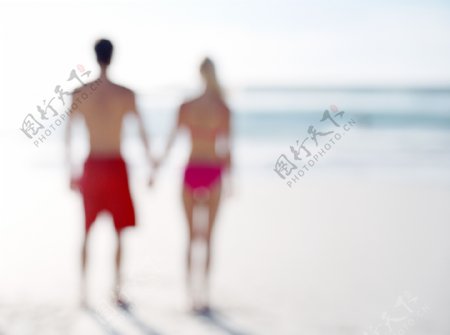 手牵手走在沙滩上的情侣图片