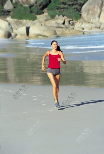 沙滩上散步的健康女性图片