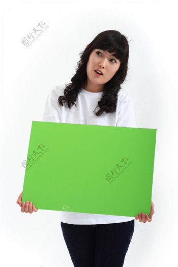 抱着绿色牌子的卷发韩国美女图片