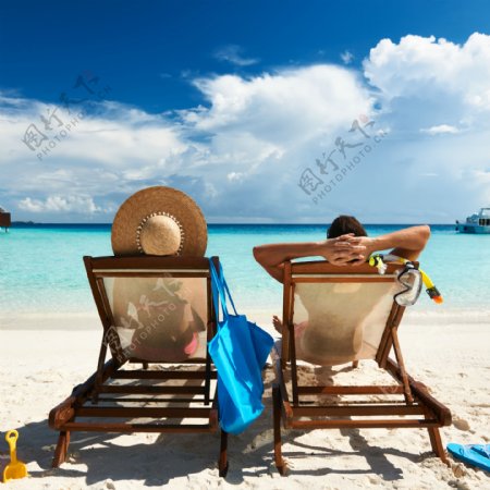 休闲椅上看海边的情侣图片