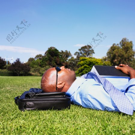 躺在草地上的商务男性图片