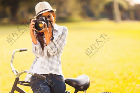 坐在自行车上拍照的美女摄影师图片