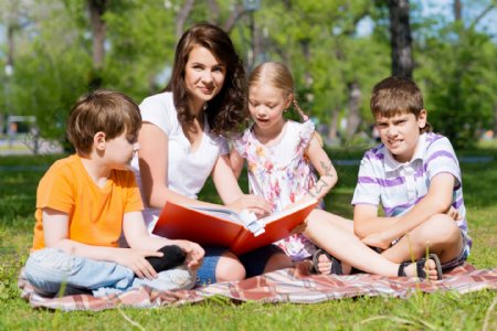 坐在草坪上看书的一家人图片