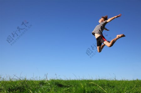 草地上跳跃的孩子图片