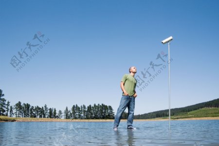 站立在水面上的男人与摄像头图片