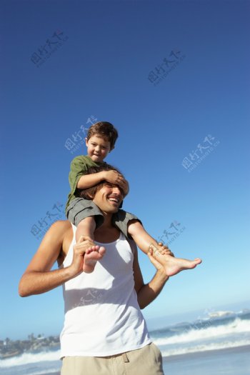 坐在父亲肩膀上的小男孩图片