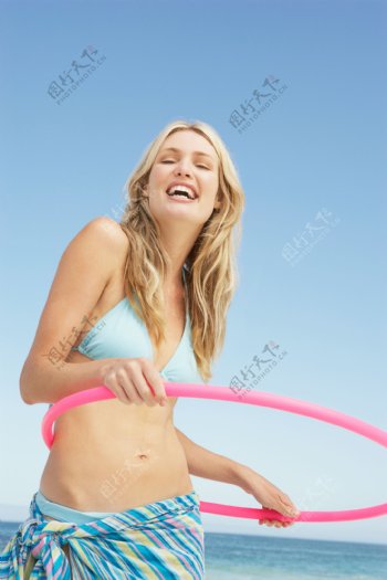 沙滩上玩呼拉圈的性感美女图片