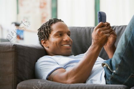 躺在沙发上玩手机的男人图片