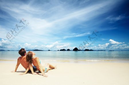坐在海边沙滩上的情侣图片