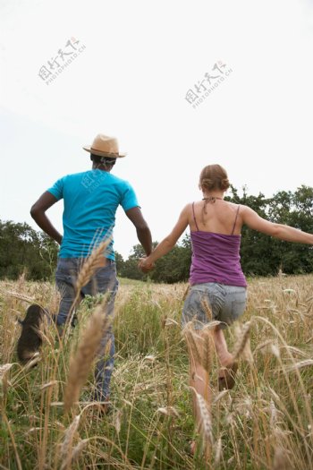 草地上奔跑的情侣图片